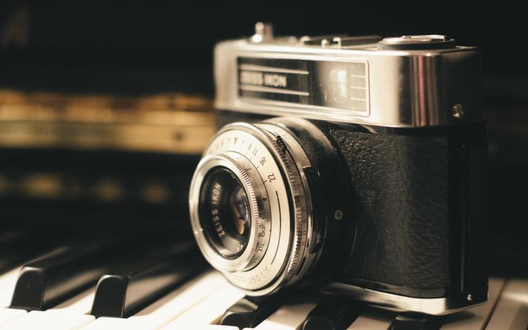 A vintage rangefinder camera on a piano